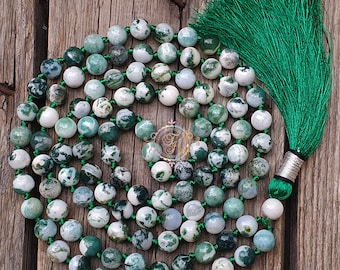 May include: A green and white agate mala necklace with a green tassel. The necklace is made of 108 beads and is approximately 18 inches long.