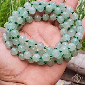 May include: A green jade beaded necklace with green string. The beads are round and smooth.