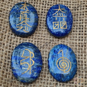 May include: Four smooth, oval-shaped lapis lazuli stones with gold symbols etched on them. The symbols are "Jin", "Kyo", "Rei", and "Sei".