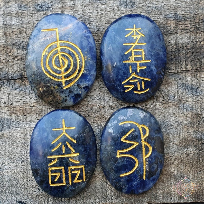 Puede incluir: Cuatro piedras lisas de lapisl&aacute;zuli azul ovaladas con s&iacute;mbolos dorados grabados en la superficie. Los s&iacute;mbolos son "木 (madera)", "火 (fuego)", "土 (tierra)" y "金 (metal)".