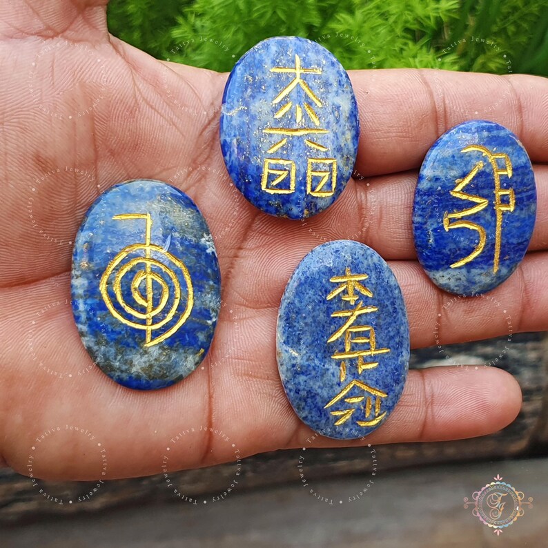 May include: Four oval-shaped lapis lazuli stones with gold symbols inscribed on them. The symbols are "Prosperity", "Health", "Harmony", and "Abundance".