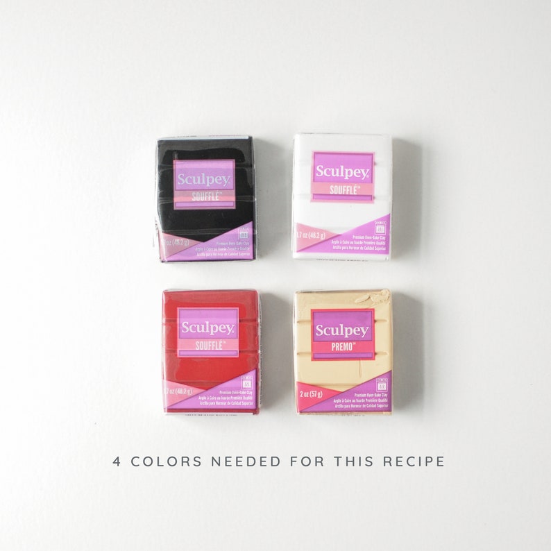Puede incluir: Cuatro bloques de arcilla polim&eacute;rica en negro, blanco, rojo y beige. Cada bloque est&aacute; etiquetado con la marca "Sculpey" y la l&iacute;nea de productos "Souffle" o "Premo". El texto "4 COLORS NEEDED FOR THIS RECIPE" est&aacute; en la parte inferior.