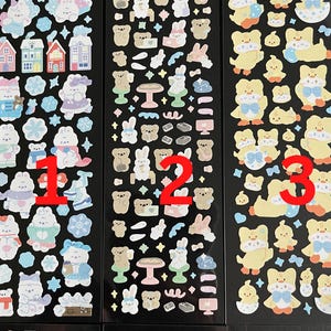 May include: Three sheets of stickers with various cute animal designs. The first sheet features a winter theme with penguins, snowmen, and houses. The second sheet features bears, bunnies, and other woodland creatures. The third sheet features yellow chicks with blue bows.