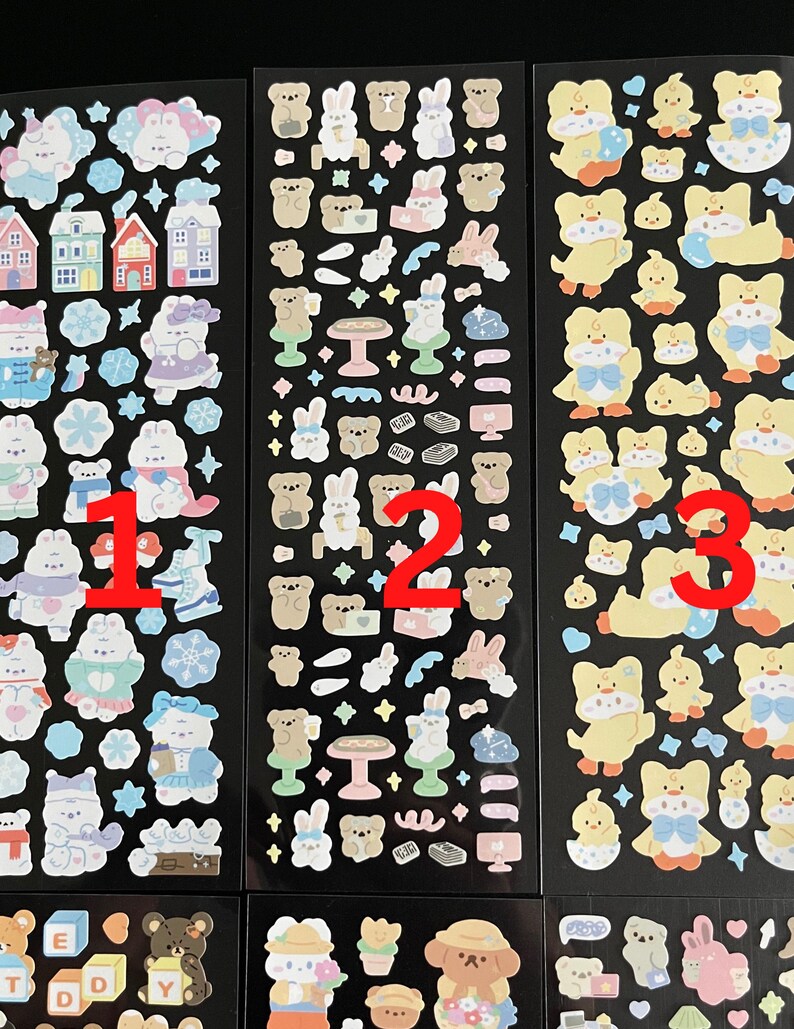 May include: Three sheets of stickers with various cute animal designs. The first sheet features a winter theme with penguins, snowmen, and houses. The second sheet features bears, bunnies, and other woodland creatures. The third sheet features yellow chicks with blue bows.
