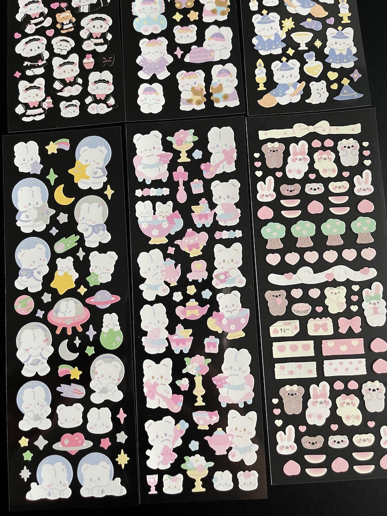 May include: A sheet of colorful stickers featuring cute cartoon bunnies in various poses and settings. The stickers include bunnies in space, bunnies having tea parties, and bunnies with hearts and flowers.