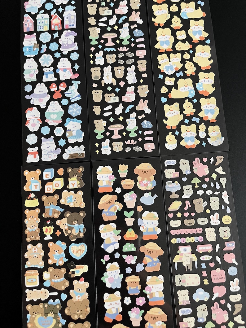 May include: Six sheets of colorful stickers featuring cute cartoon bears, bunnies, and chicks. The stickers are on a black background and are perfect for decorating planners, journals, and other items.