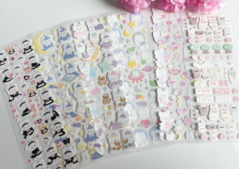 May include: A sheet of colorful stickers featuring cute cartoon bears in various poses and outfits. The stickers are on a clear background and are perfect for decorating planners, journals, and other items.