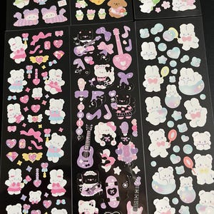May include: A sheet of stickers featuring cute cartoon bears, hearts, stars, and other whimsical designs. The stickers are on a black background and are perfect for decorating journals, planners, laptops, and other items.