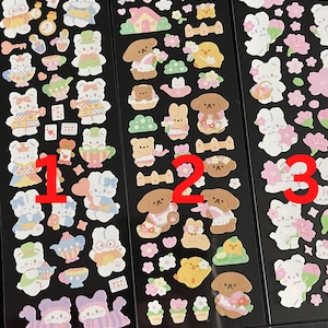 May include: Three sheets of stickers featuring cute cartoon characters. The first sheet features a bunny in a dress, a teapot, and a teacup. The second sheet features a dog in a dress, flowers, and a bird. The third sheet features a bunny in a dress, flowers, and a bird.