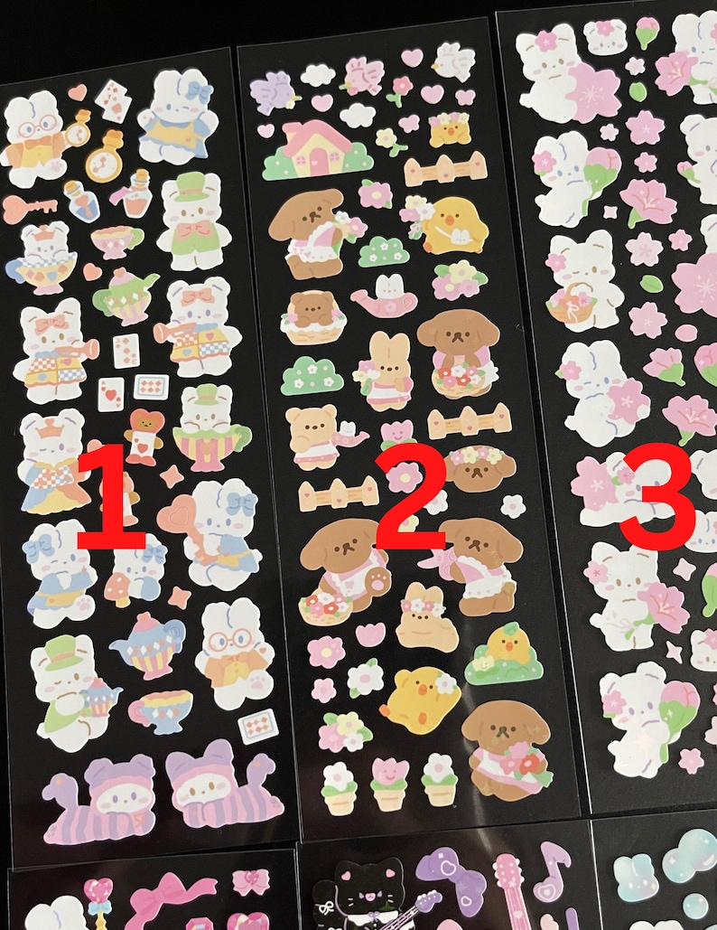 May include: Three sheets of stickers featuring cute cartoon characters. The first sheet features a bunny in a dress, a teapot, and a teacup. The second sheet features a dog in a dress, flowers, and a bird. The third sheet features a bunny in a dress, flowers, and a bird.