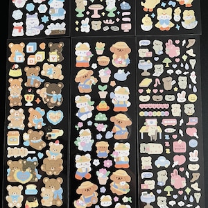 May include: A sheet of colorful stickers featuring cute cartoon bears, flowers, and other designs. The stickers are perfect for adding a touch of whimsy to journals, planners, and other craft projects.