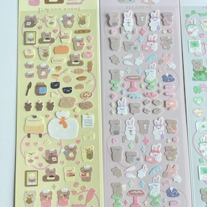 Puede incluir: Tres hojas de pegatinas con osos y conejos de dibujos animados. Las pegatinas est&aacute;n sobre un fondo amarillo, rosa y azul. Las pegatinas son perfectas para a&ntilde;adir un toque de fantas&iacute;a a tu agenda, diario o port&aacute;til.