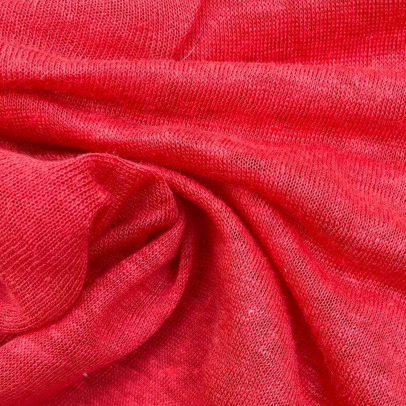 May include: Close-up of a red knitted fabric with a textured surface.