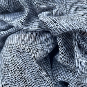 May include: Close-up of a gray and white striped fabric with a textured, ribbed surface.