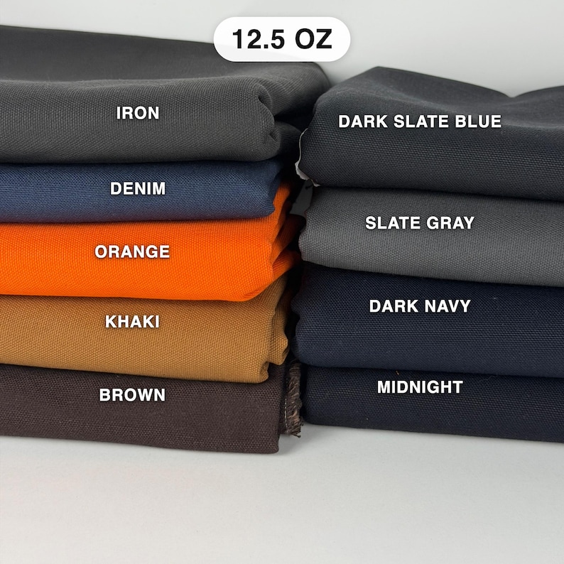 Puede incluir: Una pila de muestras de tela de 12,5 oz en varios colores, incluyendo iron, denim, orange, khaki, brown, dark slate blue, slate gray, dark navy y midnight. Cada pieza de tela est&aacute; etiquetada con su nombre de color correspondiente en texto blanco.