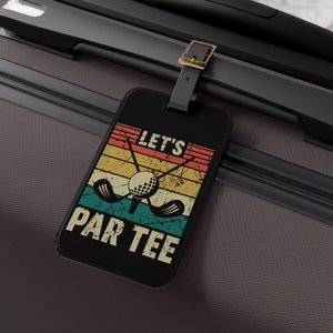 May include: Black luggage tag with a vintage-style graphic of golf clubs and a golf ball. The text "Let's Par Tee" is printed in white on the tag.