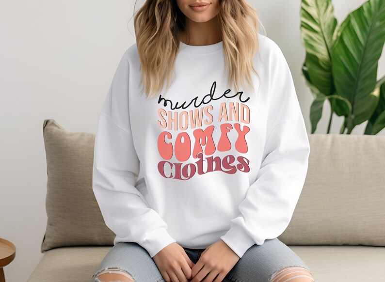 May include: White sweatshirt with the text "murder shows and comfy clothes" in black and pink lettering.