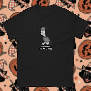 May include: Black t-shirt with a cartoon raven design and the text "QUOTH THE RAVEN... EAT MY SHORTS" in white. The design is a parody of a famous poem. The shirt is made of a soft, comfortable material.
