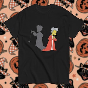 Op de afbeelding: Zwart T-shirt met een cartoonafbeelding van een personage in een rode jurk en de schaduw van een persoon met een touwtje. Het ontwerp is in de stijl van een populaire animatieserie. Het shirt is gemaakt van zacht materiaal.