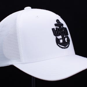 May include: White mesh back baseball cap with a black embroidered anchor and the letters "USN" on the front.
