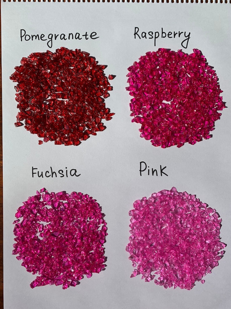 May include: Four piles of red, pink, and fuchsia colored glass pieces labeled "Pomegranate", "Raspberry", "Fuchsia", and "Pink".
