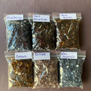 May include: Six small bags of crushed glass, each labeled with a color name: Blueberry, Dark Chocolate, Dark Brown, Brown, Coffee, and Wet Asphalt.