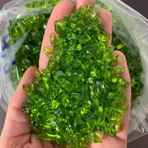May include: A handful of green glass pieces, likely for use in crafts or decorative purposes.