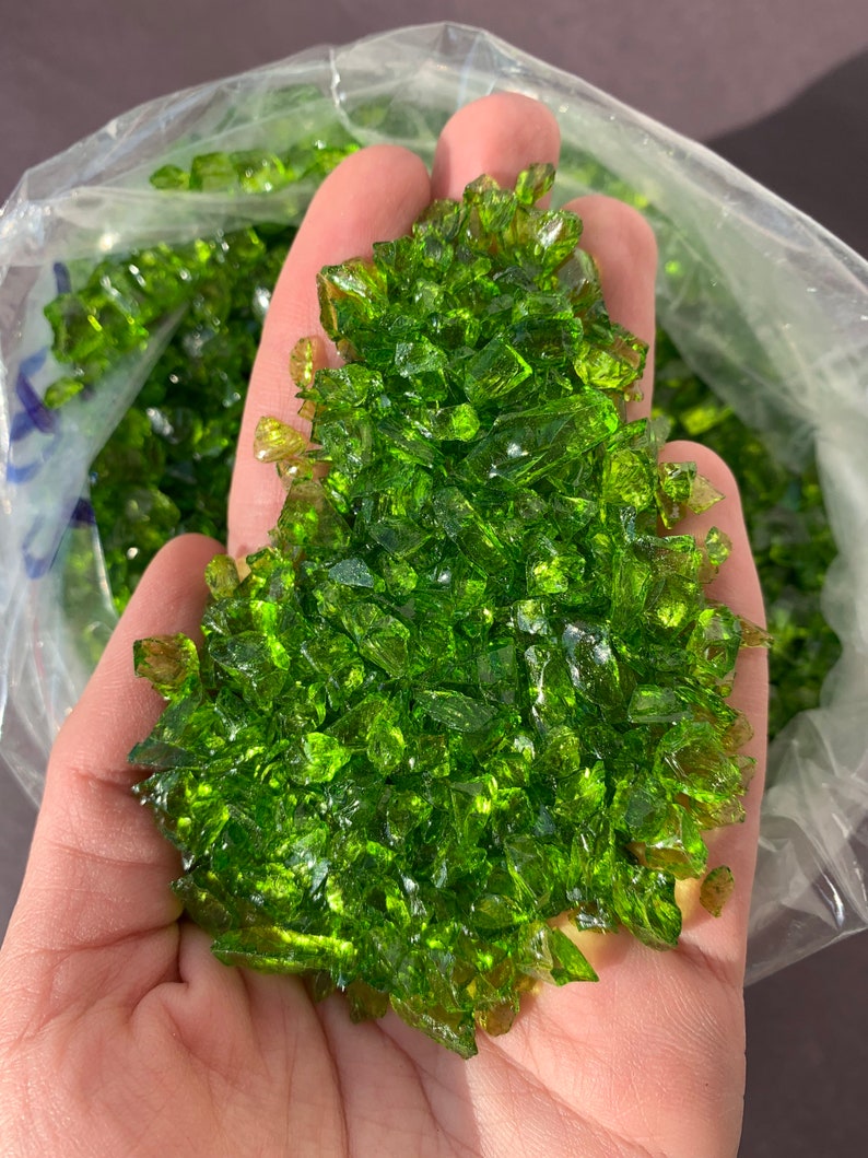 May include: A handful of green glass pieces, likely for use in crafts or decorative purposes.