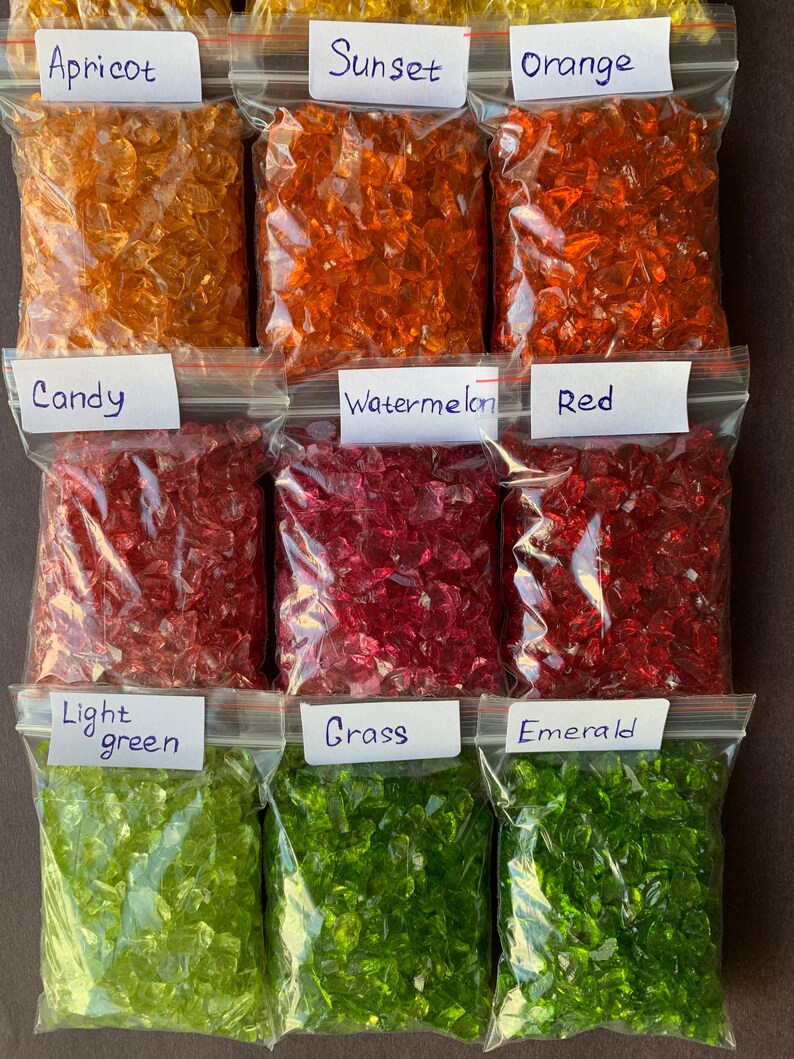 May include: Nine bags of crushed glass, each labelled with a colour name. The colours are: Apricot, Sunset, Orange, Candy, Watermelon, Red, Light Green, Grass, and Emerald.