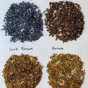 May include: Four piles of crushed glass in different colors: blueberry, dark chocolate, dark brown, and brown.