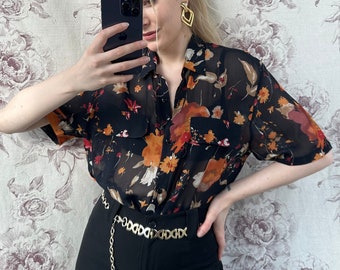 Vintage doorschijnende zwarte oversized blouse, elegant doorschijnend oranje en rode bloemenprint shirt met korte mouwen