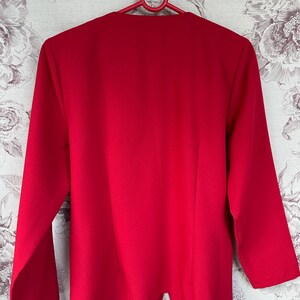 Puede incluir: Una chaqueta roja de manga larga con cuello en V.