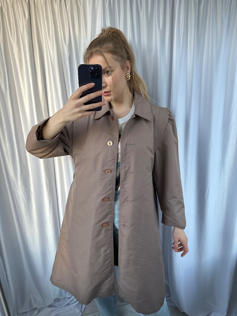 May include: A long-sleeved, brown, collared jacket with a button-up front. The jacket has a slightly fitted silhouette and features a subtle texture.
