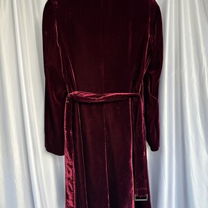 May include: A long-sleeved burgundy velvet coat with a self-tie belt and a classic collar.
