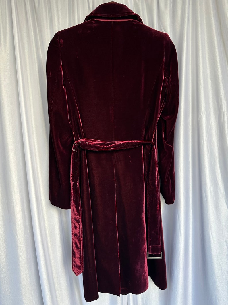 May include: A long-sleeved burgundy velvet coat with a self-tie belt and a classic collar.