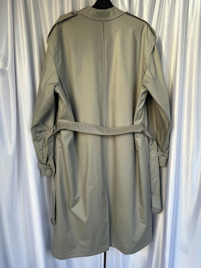 May include: A long, light gray trench coat with a belt and a single back seam. The coat has a collar and long sleeves.