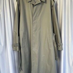 May include: A long, light green trench coat with a belt and buckle closures on the sleeves.