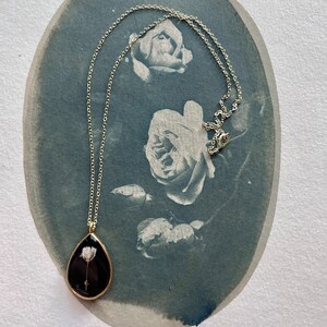 Geperst Bloem Ketting Hars Goud Teardrop Frame Gipskruid Zwarte Achtergrond