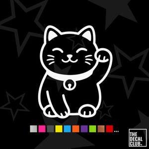 May include: A white line art decal of a beckoning cat with a collar and bell, centred on a black background with star patterns. Below the cat is a row of coloured squares and the text THE DECAL CLUB in a white square box in the bottom corner.