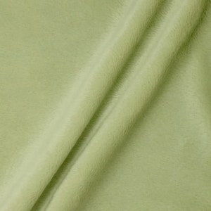 May include: A close-up of a soft, light green fabric with a smooth texture. The fabric is folded in half, creating a subtle crease.