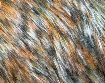 Könnte beinhalten: Ein dichter Kunstpelzstoff mit langem Flor in einer abwechslungsreichen Farbpalette aus gebranntem Orange, Anthrazitgrau, Creme und gedämpftem Olivgrün. Die Fasern sind diagonal ausgerichtet und erzeugen ein strukturiertes, mehrfarbiges Erscheinungsbild.