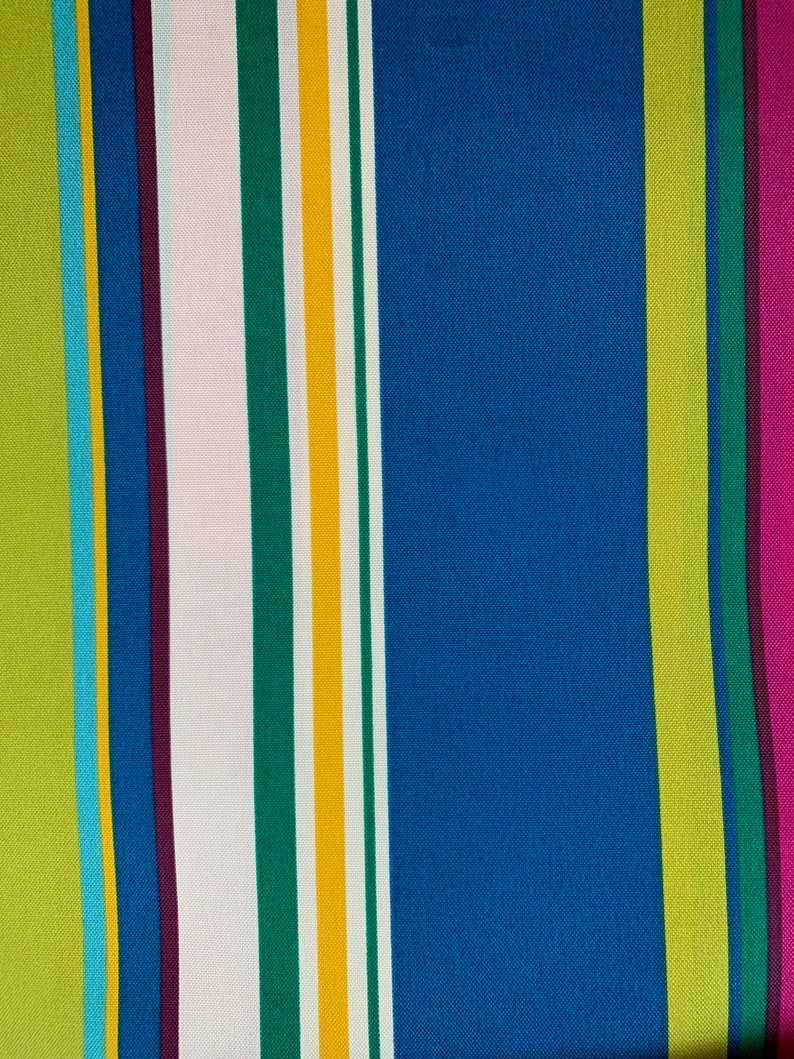 May include: A colorful striped fabric with alternating bands of green, yellow, white, blue, purple, and pink.