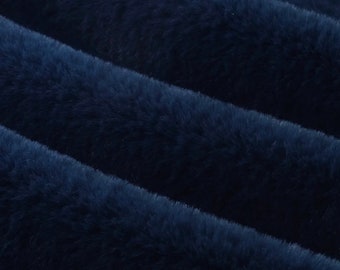 Könnte beinhalten: Nahaufnahme eines plüschigen, marineblauen Stoffes mit weicher, pelziger Textur. Der Stoff ist in diagonalen Falten angeordnet, wodurch ein Gefühl von Tiefe entsteht und das luxuriöse Gefühl hervorgehoben wird. Ideal für Decken, Überwürfe oder Kleidung.