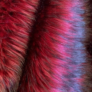May include: Close-up of a plush fabric with a gradient of dark red and black. The fabric has a soft, fuzzy texture.