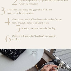 May include: A close-up of a hand holding a strand of white pearls. The pearls are strung on a thin wire. The hand is wearing a brown sweater and a gold bracelet. The background is a blurry image of a table and a window.