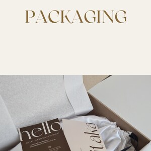 May include: A white satin bag with a black drawstring and a small card that says "Vitaka" is inside a brown cardboard box. The box is open and the bag is visible. A small card with the text "hello ITSME YOUR PERFECT AD BAG" is also visible.