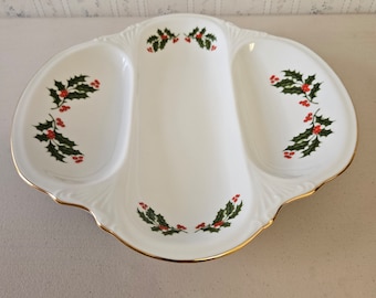 May include: A white ceramic serving dish with three sections. The dish is decorated with a green holly leaf and red berry design. The rim of the dish is trimmed with a gold band.