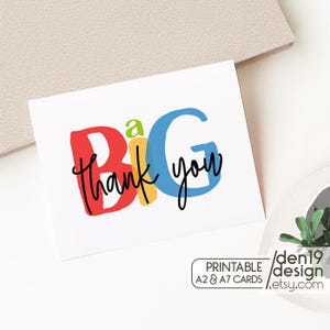 Op de afbeelding: Een witte kaart met de tekst "a BIG thank you" in kleurrijke, speelse letters. De "B" is rood, de "a" is groen, de "G" is blauw en "thank you" is zwart. De kaart bevat ook de tekst "PRINTABLE A2 & A7 CARDS" en een websiteadres.