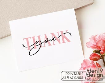 Puede incluir: Una tarjeta blanca con las palabras "Thank you" en rosa y negro. La tarjeta está junto a flores rosas y un sobre beige claro. La tarjeta también tiene el texto "PRINTABLE A2 & A7 CARDS" y una dirección web.