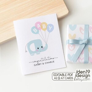 May include: A baby shower greeting card featuring a light blue elephant holding balloons that spell "BABY". The card includes the text "congratulations" and the names "Gabby & Charlie". A wrapped gift with a light blue ribbon is also visible.